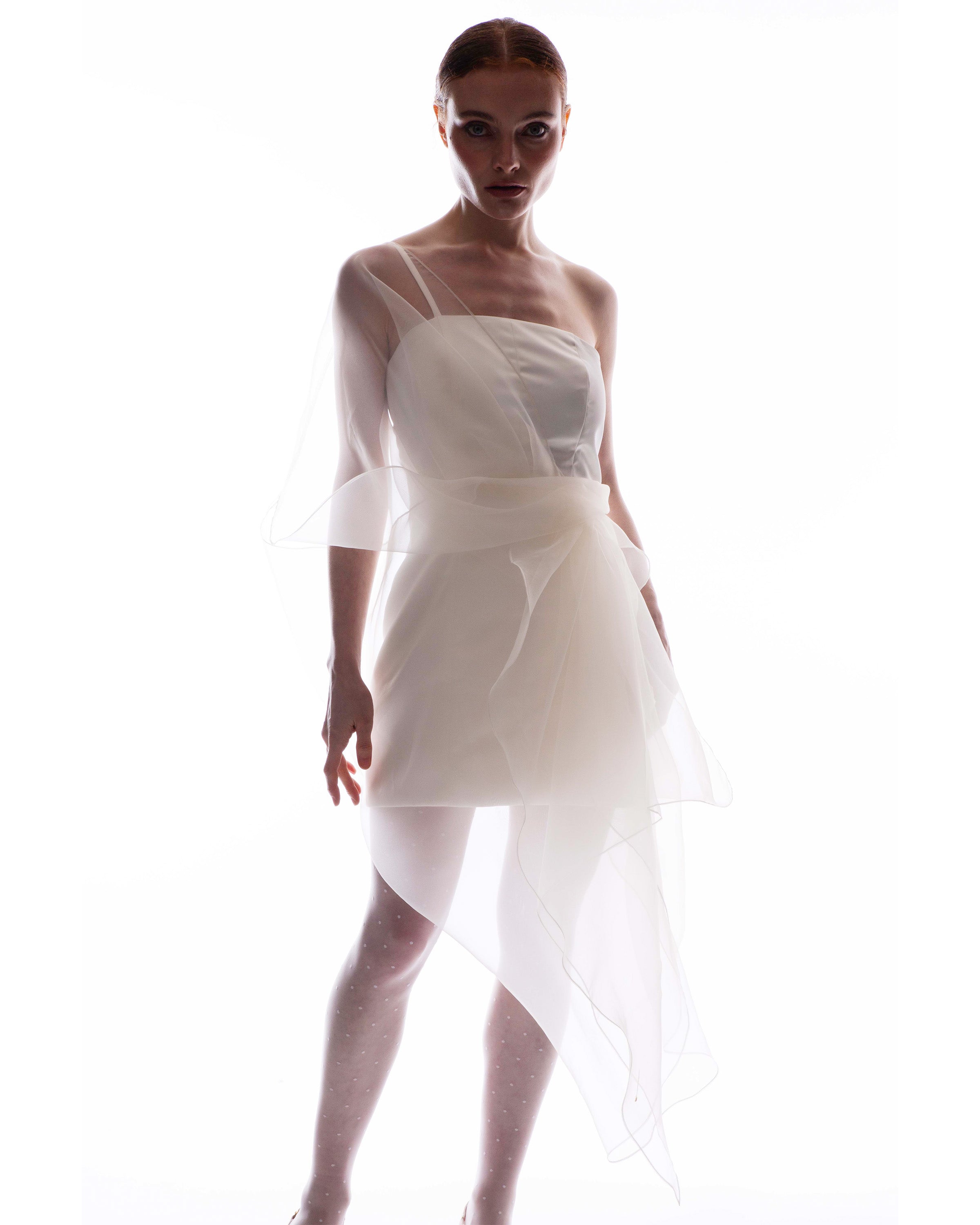 Woman wearing the Henrietta organza wrap dress, white one-shoulder organza dress against a white background